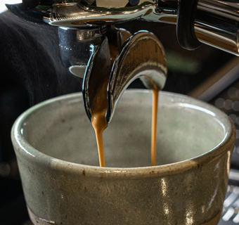 Kaffee läuft aus einer Siebträgermaschine in eine Tasse